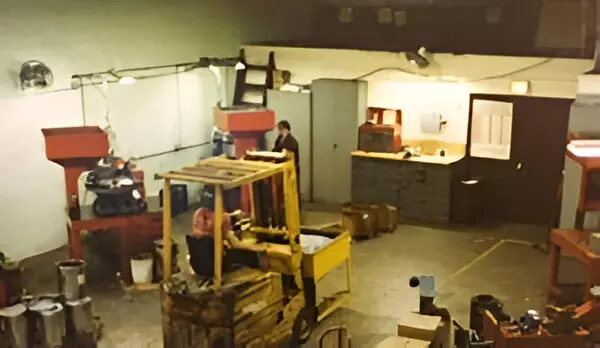 Warehouse interior with forklift and machinery.